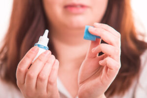 Woman holdin eye drops in hand